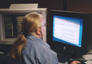 Fig. 5. Debbie Swisher compares printed copies of eighteenth-century North Carolina law with the microfiche version, adjusting the computer image for maximum quality and tagging the file with "metadata," including cross-references.