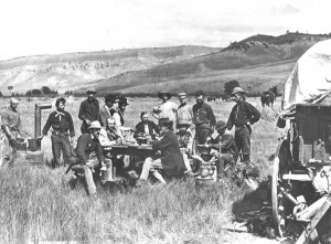 "Members of the Hayden Survey near Red Buttes, Wyoming Territory, August 1870." Hayden is seated hatless in the center at the back of the table; Jackson stands at the right, left hand on his hip. W. H. Jackson photo, courtesy of the USGS archives.