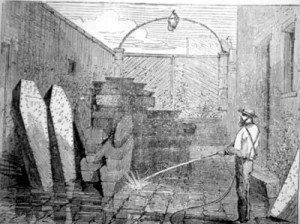 "Bodies at the Morgue Awaiting Identification and Removal," from J. F. Richmond, New York and Its Institutions (New York, 1871-72). A worker using a hose to wash a room stacked with caskets; two caskets stand upright against the wall at far left. Courtesy of the American Antiquarian Society.