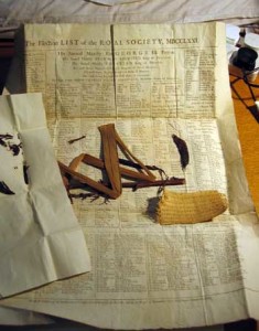 Fig. 6. Some leaves, part of the flower stem, some seed pods, and a bit of woven cloth folded in a sheet of newsprint containing "The Election List of the Royal Society MDCLLXXI (1771)." Courtesy of the Linnean Society of London.